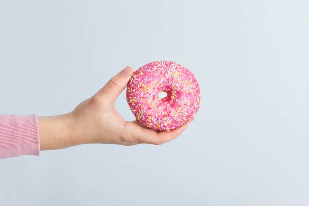 Main qui tient un donut